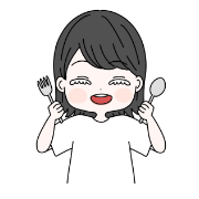 女性が笑顔でスプーンとフォークを持っている様子